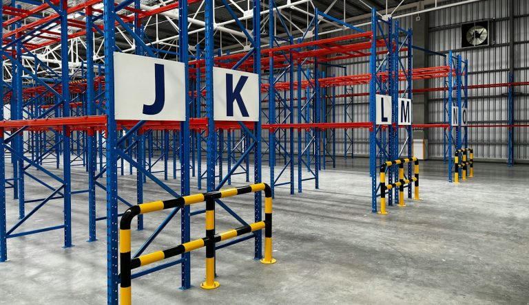 Opslagruimte met metalen stellingen en borden met letters J en K.
